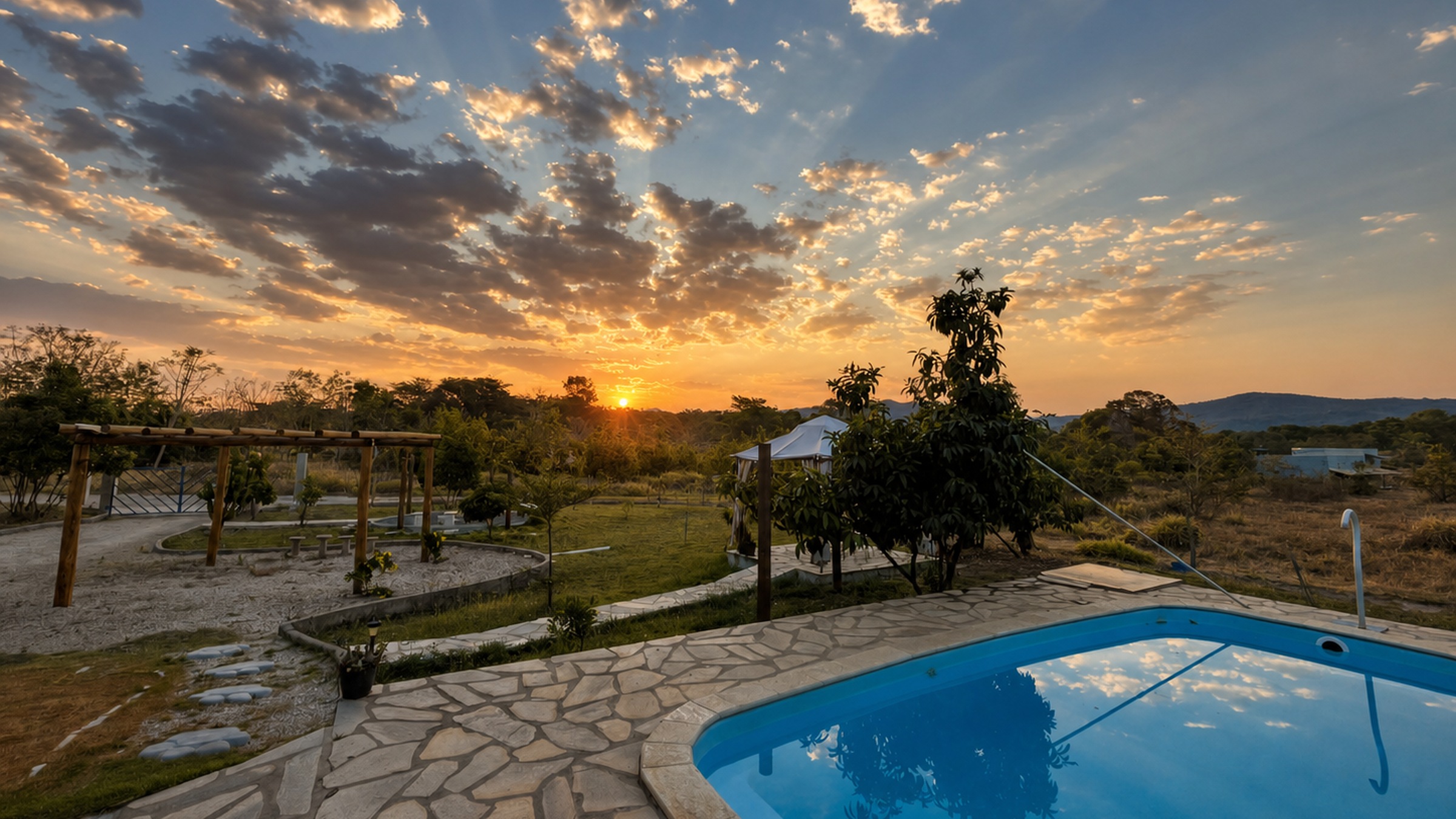 Piscina da Quinta Dona Ditinha ao pôr do sol, com a Serra dos Pireneus ao fundo
