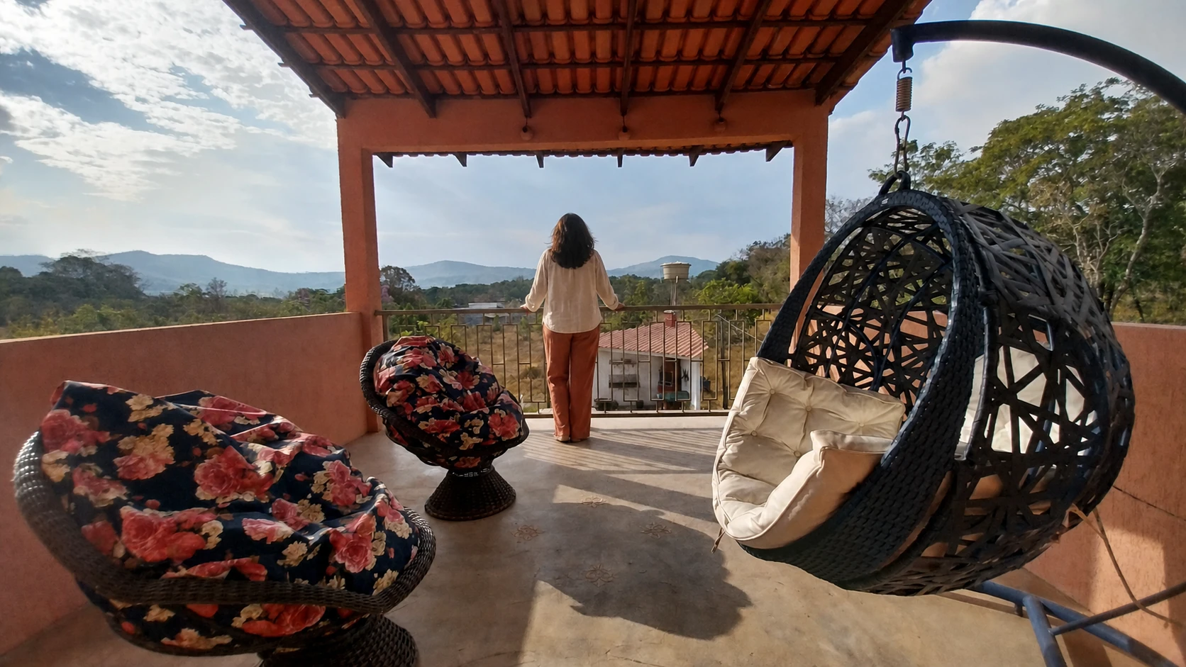Varanda superior da Quinta Dona Ditinha com poltronas e vista para a serra