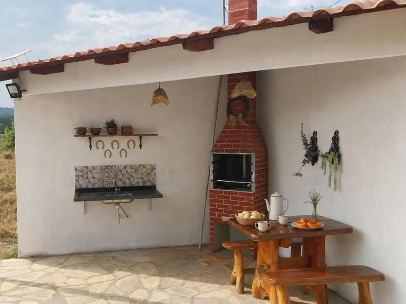 Área gourmet com churrasqueira de tijolo e mesa de madeira